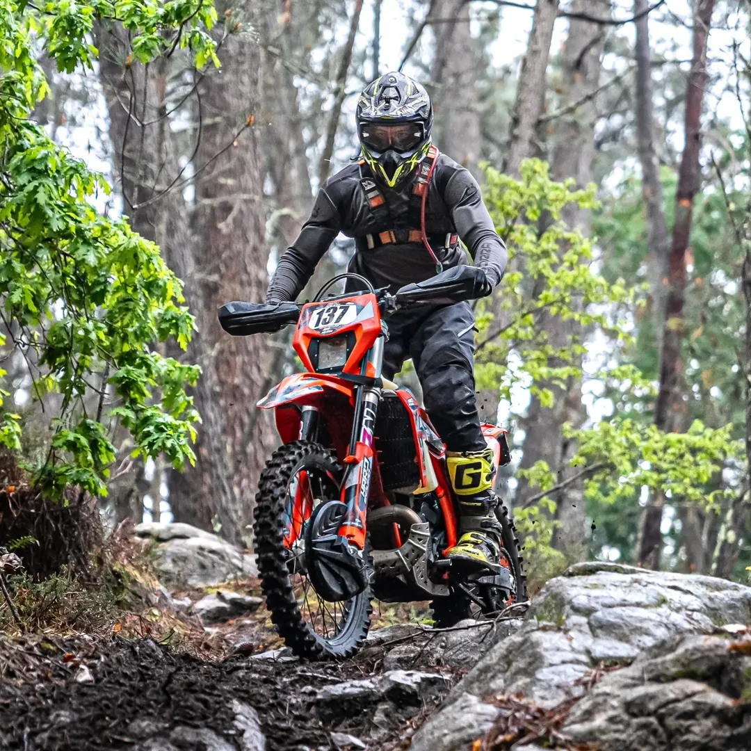 Rider tackling dirt trail on a low cost dirt bike
